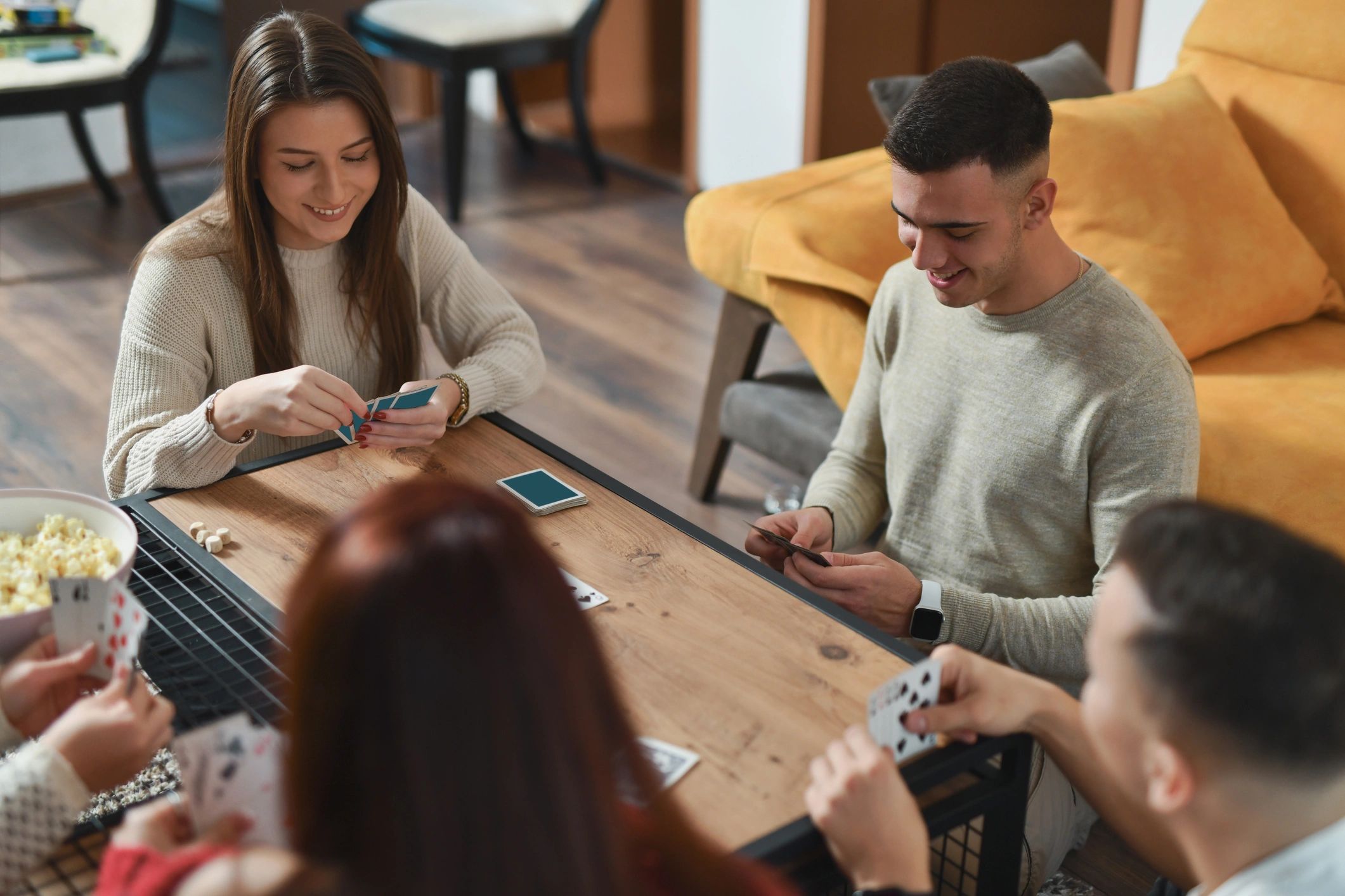 Friends gathered around a table playing a card game